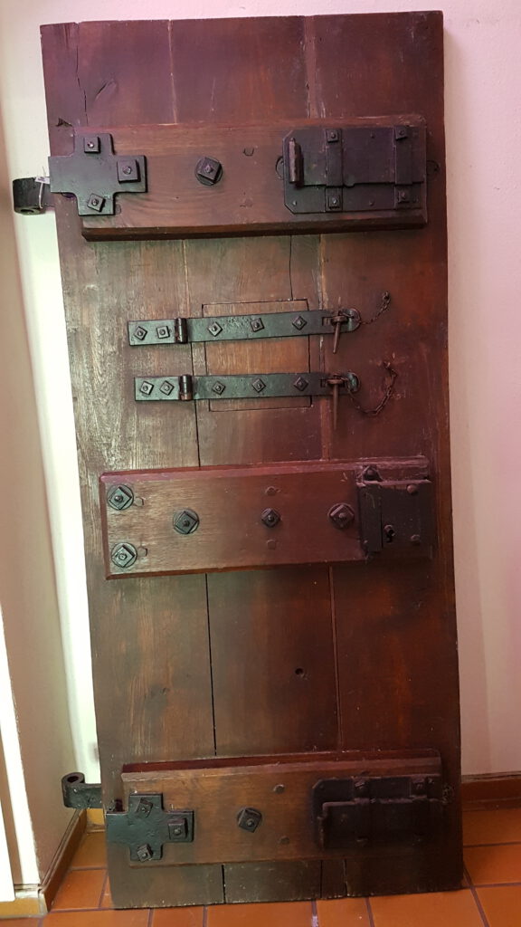 schwere, historische Haftzellentür mit Eisenscharnieren
