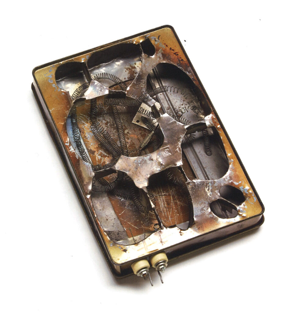 Elektrischer Pizzaofen, bestehend aus einer rechteckigen, mit Heizspiralen ausgekleideten Keksdose aus Metall, die über elektrische Anschlüsse unter Strom gesetzt werden kann, als Objekt im Strafvollzugsmuseum ausgestellt
